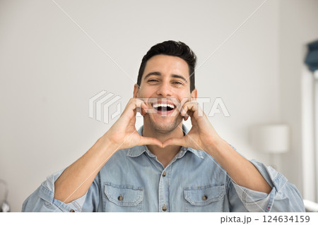 Portrait of laughing Hispanic guy gesturing, fooling, looking at camera 124634159