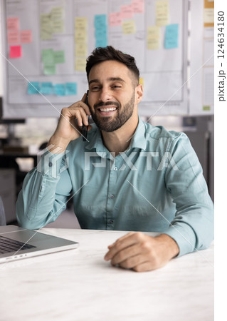 Happy businessman talking to mobile phone at office workplace table 124634180