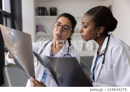 Senior trauma surgeon showing roentgen image to young intern 124634279