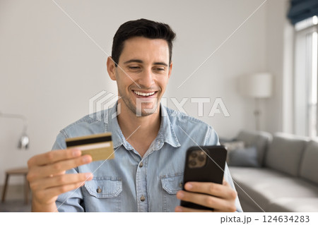 Man using card and phone purchasing through marketplace application Man using card and phone purchasing through marketplace application 124634283