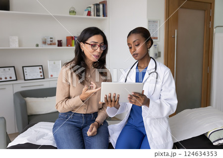 Serious physician showing electronic examination result to senior patient 124634353