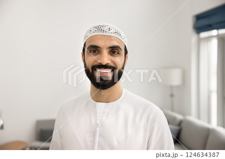 Cheerful Arabic man posing in living room 124634387