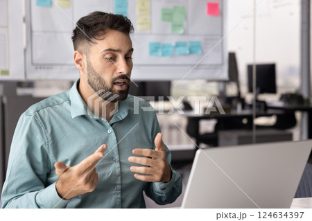 Serious busy confident Hispanic businessman talking on online conference chat 124634397
