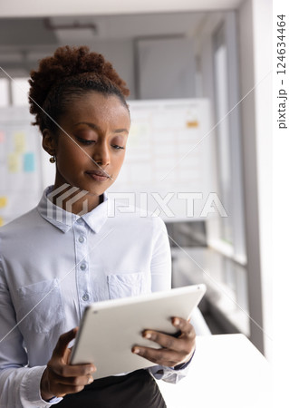 Serious young African businesswoman working on Internet startup 124634464