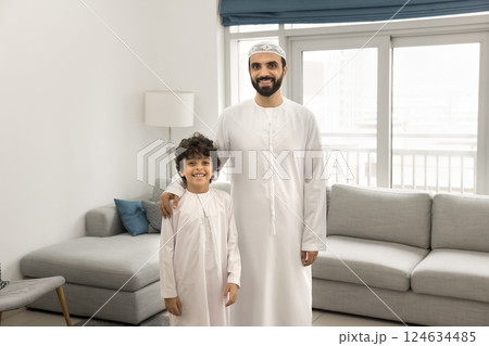 Arabic father and little son standing together in living room 124634485