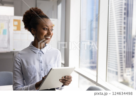 Happy young African business executive woman using digital tablet 124634498