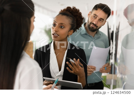 Young African businesswoman talking to colleagues, meeting with coworkers 124634500
