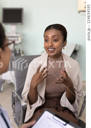 Happy young African American patient woman visiting doctor in clinic Happy young African American patient woman visiting doctor in clinic 124634595