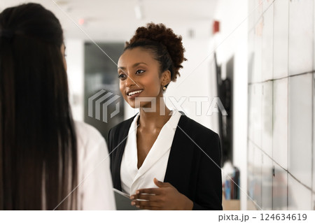 Happy beautiful young business professional woman talking to work colleague 124634619