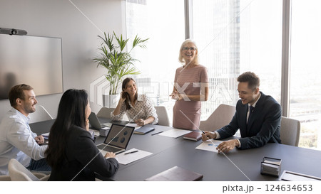 Older businesswoman leading discussion with shareholders in boardroom Older businesswoman leading discussion with shareholders in boardroom 124634653