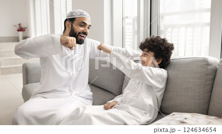 Arab man and his little 7s cute son sharing fist-bump Arab man and his little 7s cute son sharing fist-bump 124634654