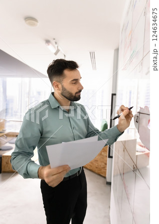 Serious Latin manager man using Kanban scrum board Serious Latin manager man using Kanban scrum board 124634675