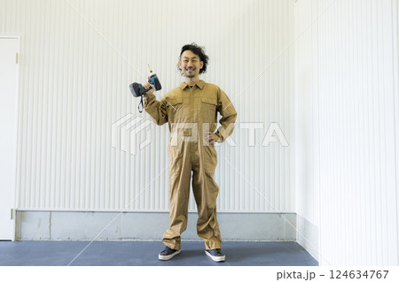 倉庫の中を歩くつなぎの男性  124634767