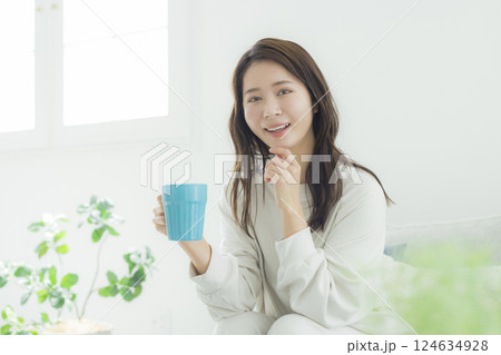 部屋でコーヒーを飲む女性 部屋でコーヒーを飲む女性 124634928