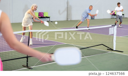 Man and woman training to play pickleball tennis on the pickleball cour Man and woman training to play pickleball tennis on the pickleball cour 124637566