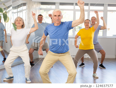 Portrait of active mature people enjoying modern energetic dancing in a group in studio Portrait of active mature people enjoying modern energetic dancing in a group in studio 124637577