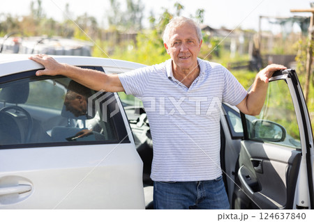 Elderly man posing by car in garden 124637840