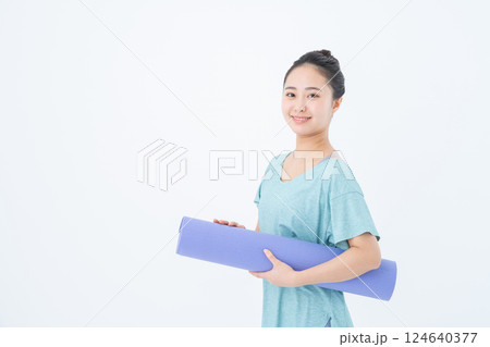 ヨガマットを持つ若い女性 124640377