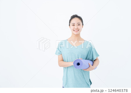 ヨガマットを持つ若い女性 124640378