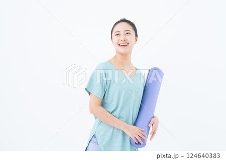 ヨガマットを持つ若い女性 124640383