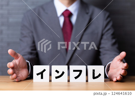 インフレのブロックとスーツを着たミドル男性ビジネスマン インフレのブロックとスーツを着たミドル男性ビジネスマン 124641610