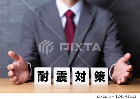 耐震対策のブロックとスーツを着たミドル男性ビジネスマン 耐震対策のブロックとスーツを着たミドル男性ビジネスマン 124641612