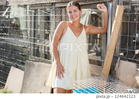 Young woman posing near hen house Young woman posing near hen house 124642123