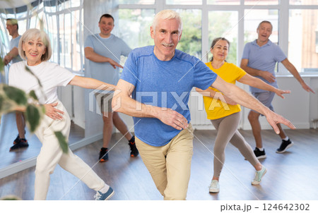 Man participating in Zumba class for group of seniors in fitness studio Man participating in Zumba class for group of seniors in fitness studio 124642302