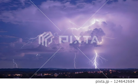 Powerful thunderstorm with lightning in night sky illuminate the clouds with purple-blue hues 124642684