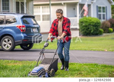 Landscape design. Lawn mower landscaping. Backyard grass maintenance. Hispanic gardener. Lawnmower mow green grass. Man gardener cut the grass. Garden care. Electric lawn mower. Mower for large lawns 124642986