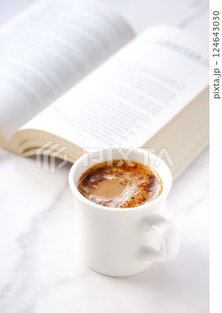 コーヒーを飲みながら、のんびりペーパーバック（洋書）を読んでいるイメージ 124643030