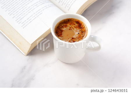 コーヒーを飲みながら、のんびりペーパーバック(洋書)を読んでいるイメージ コーヒーを飲みながら、のんびりペーパーバック(洋書)を読んでいるイメージ 124643031