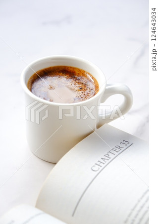 コーヒーを飲みながら、のんびりペーパーバック(洋書)を読んでいるイメージ コーヒーを飲みながら、のんびりペーパーバック(洋書)を読んでいるイメージ 124643034