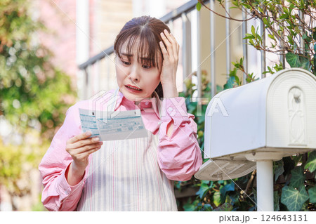 検針表を見て驚く女性 電気、ガス、水道料金 検針表を見て驚く女性 電気、ガス、水道料金 124643131