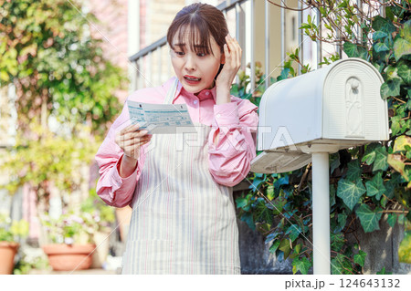 検針表を見て驚く女性 電気、ガス、水道料金 検針表を見て驚く女性 電気、ガス、水道料金 124643132