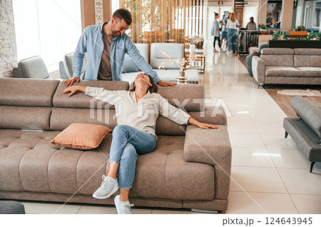 Having fun. Couple choosing the sofa and bed in the store 124643945
