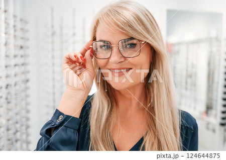 Looking at the camera. Woman in store trying new glasses Looking at the camera. Woman in store trying new glasses 124644875