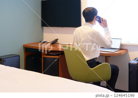 出張先のホテルで仕事をするビジネスマン 出張先のホテルで仕事をするビジネスマン 124645190