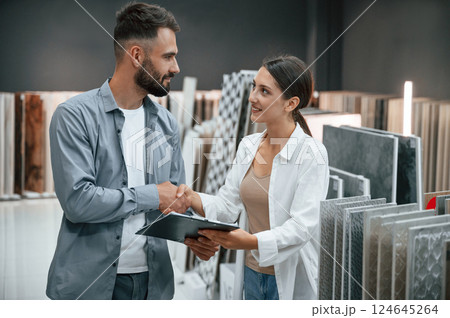 Helping the customer. Woman and man is in the store of goods for the home 124645264