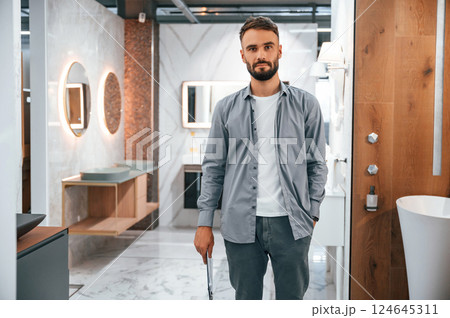 Manager with notepad. Stylish beautiul man is in the store of goods for the home 124645311