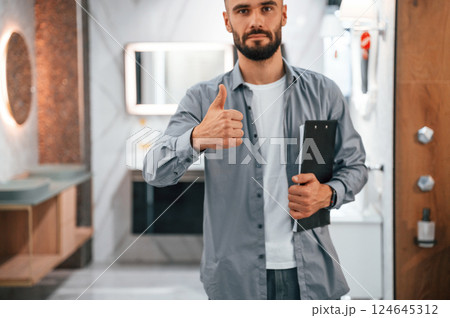 Manager with notepad. Stylish beautiul man is in the store of goods for the home Manager with notepad. Stylish beautiul man is in the store of goods for the home 124645312