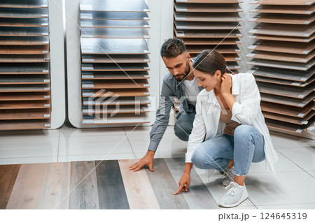 Choosing parquet. Woman and man is in the store of goods for the home 124645319
