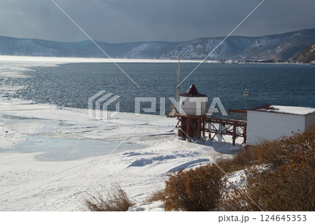 Scenic at the ice-free Angara River flows out of the frozen Lake Baikal. Melted ice floes on blue water. Located Baikal lake. Scenic at the ice-free Angara River flows out of the frozen Lake Baikal. Melted ice floes on blue water. Located Baikal lake. 124645353