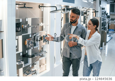 Standing and looking for new materials for home. Woman and man is in the store of goods Standing and looking for new materials for home. Woman and man is in the store of goods 124645636