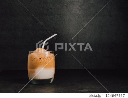 Iced or frappe coffee smoothie on a glass cup on black marble backdrop 124647537