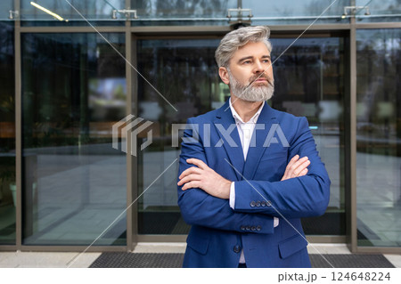 Mature confident businessman in blue suit looking determined Mature confident businessman in blue suit looking determined 124648224