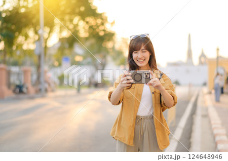 Traveler asian woman in her 30s using smartphone to take a photo while traveling urban street in Bangkok, Thailand 124648946