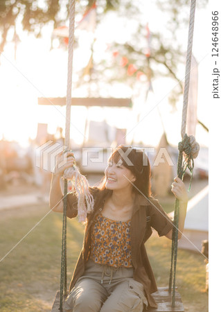 asian woman sitting in swing at camping site. 124648966