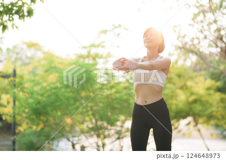 Female jogger. Fit young Asian woman with sportswear stretching muscle in park before running and enjoying healthy outdoor. Fitness runner girl in public park. Wellness being concept Female jogger. Fit young Asian woman with sportswear stretching muscle in park before running and enjoying healthy outdoor. Fitness runner girl in public park. Wellness being concept 124648973