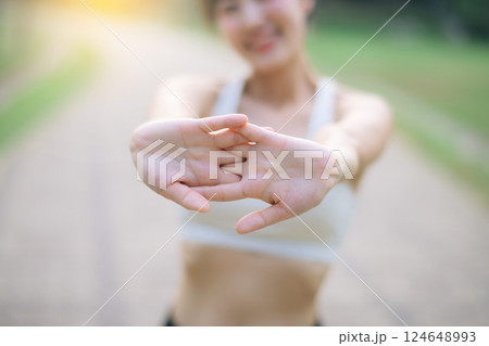 Female runner. Fit young Asian woman with sportswear stretching muscle in park before running and enjoying healthy outdoor. Fitness runner girl in public park. Wellness being concept 124648993